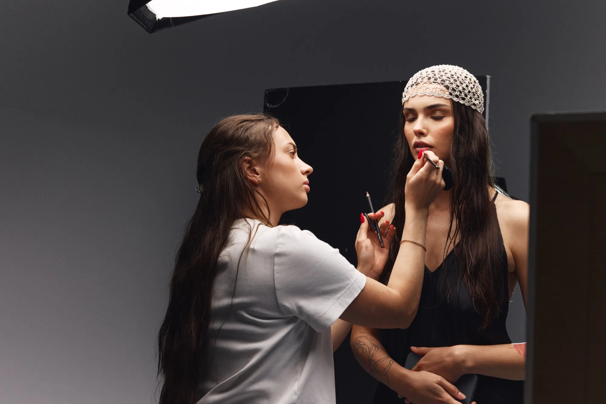 Anna applying lipstick to a model in the studio